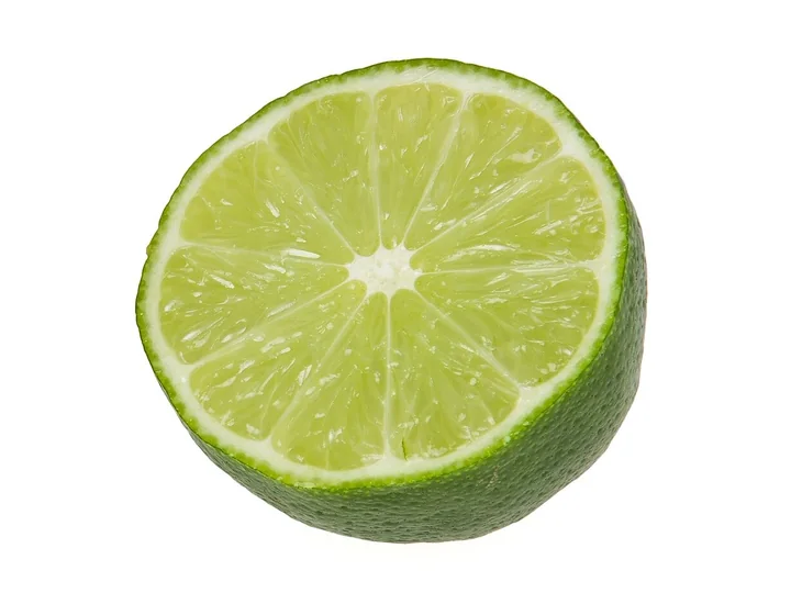 Jumătate de lime, cu coaja verde și miezul verde-deschis, împărțit în felii în jurul unui centru alb